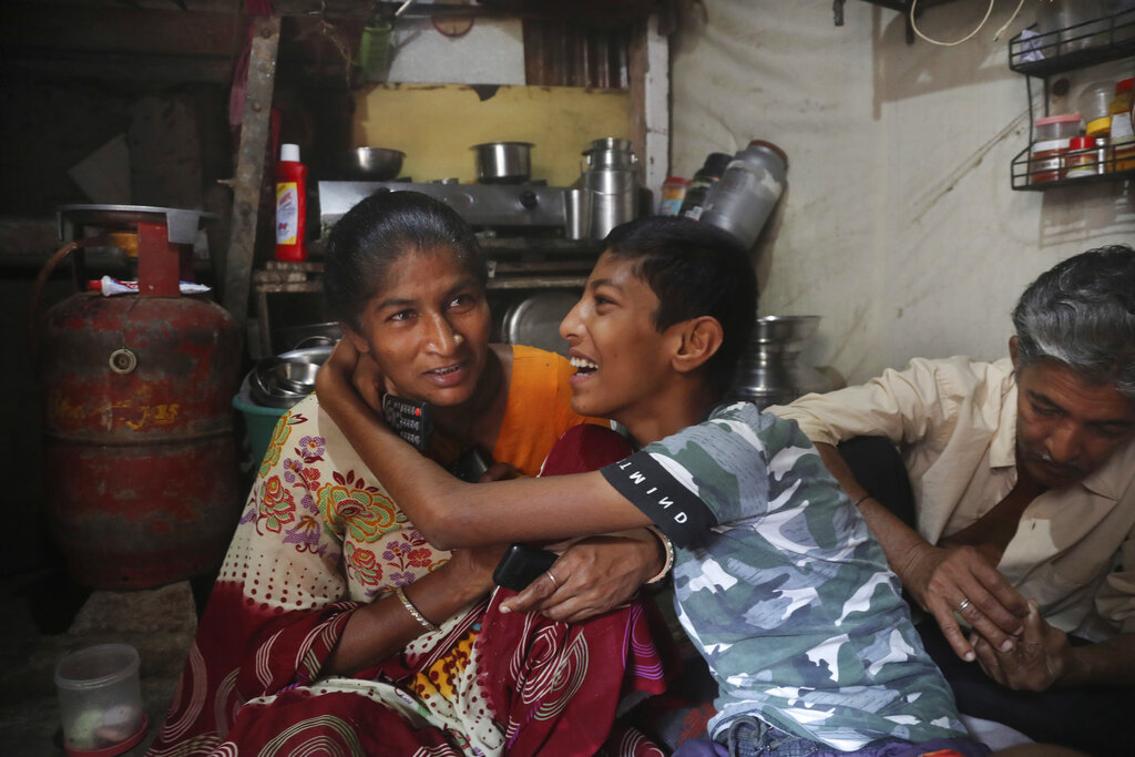 Mina, who makes a living selling cheap plastic goods with her husband on the streets of Mumbai, shares light moment with her son Ritik Ramesh. Behind Ritik is his father Ramesh Karsan Jakhawadiya