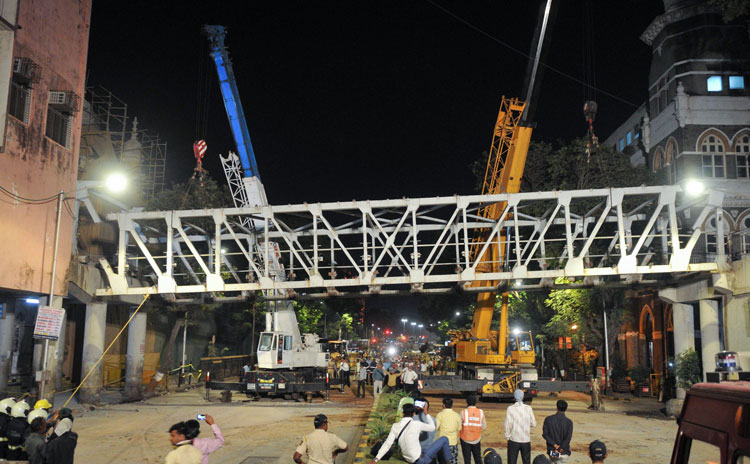 Workers dismantling the collapsed bridge in Mumbai on Friday