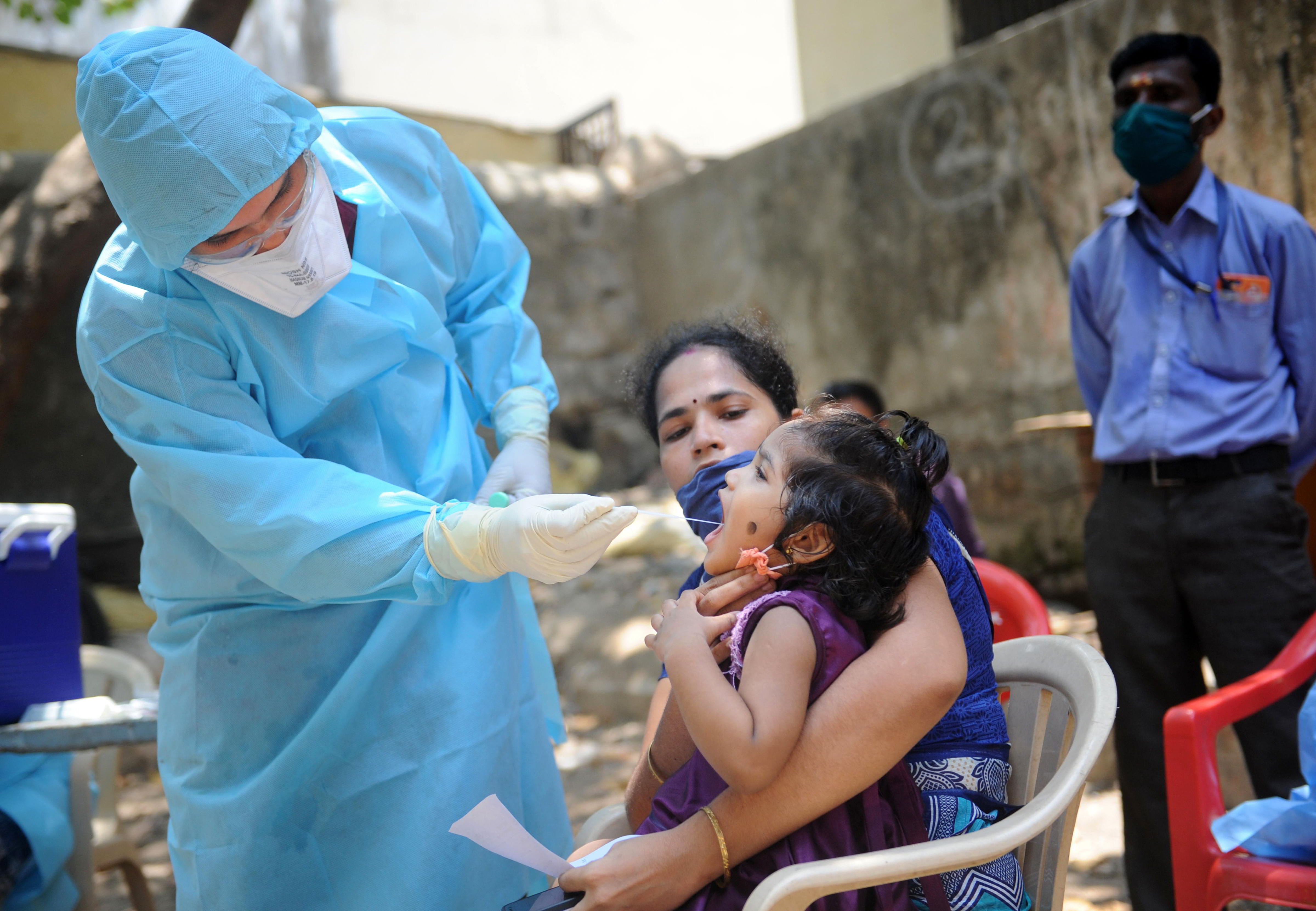 A doctor takes swab from the mouth of a child for Covid-19 test at Kalyanwadi in Dharavi slums, in Mumbai, Thursday, April 16, 2020.