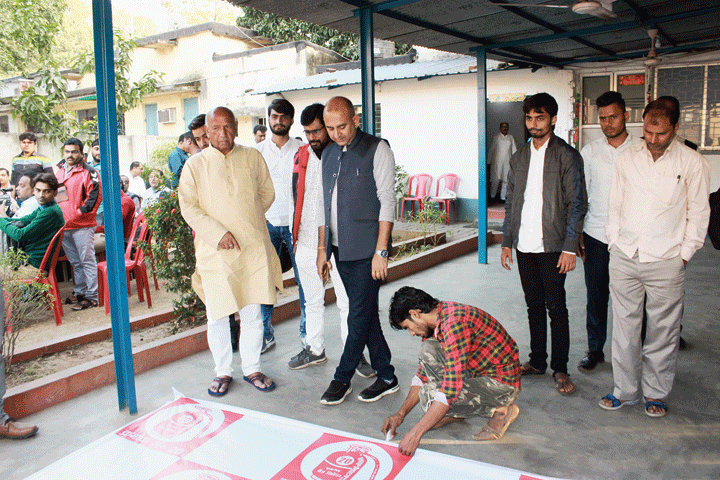 Jamshedpur East Independent candidate Saryu Roy oversees a campaign poster being made at his Bistupur residence in Jamshedpur on Monday. 