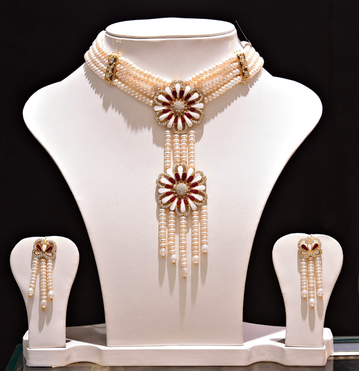 This choker set with a pair of earrings and bracelets, made of ivory freshwater pearls, spells elegance. The double pendants studded with cubic zircons on gold-polished silver alloy can be paired with a cocktail dress. 
Rs 17,000 @ Chandrani Pearls