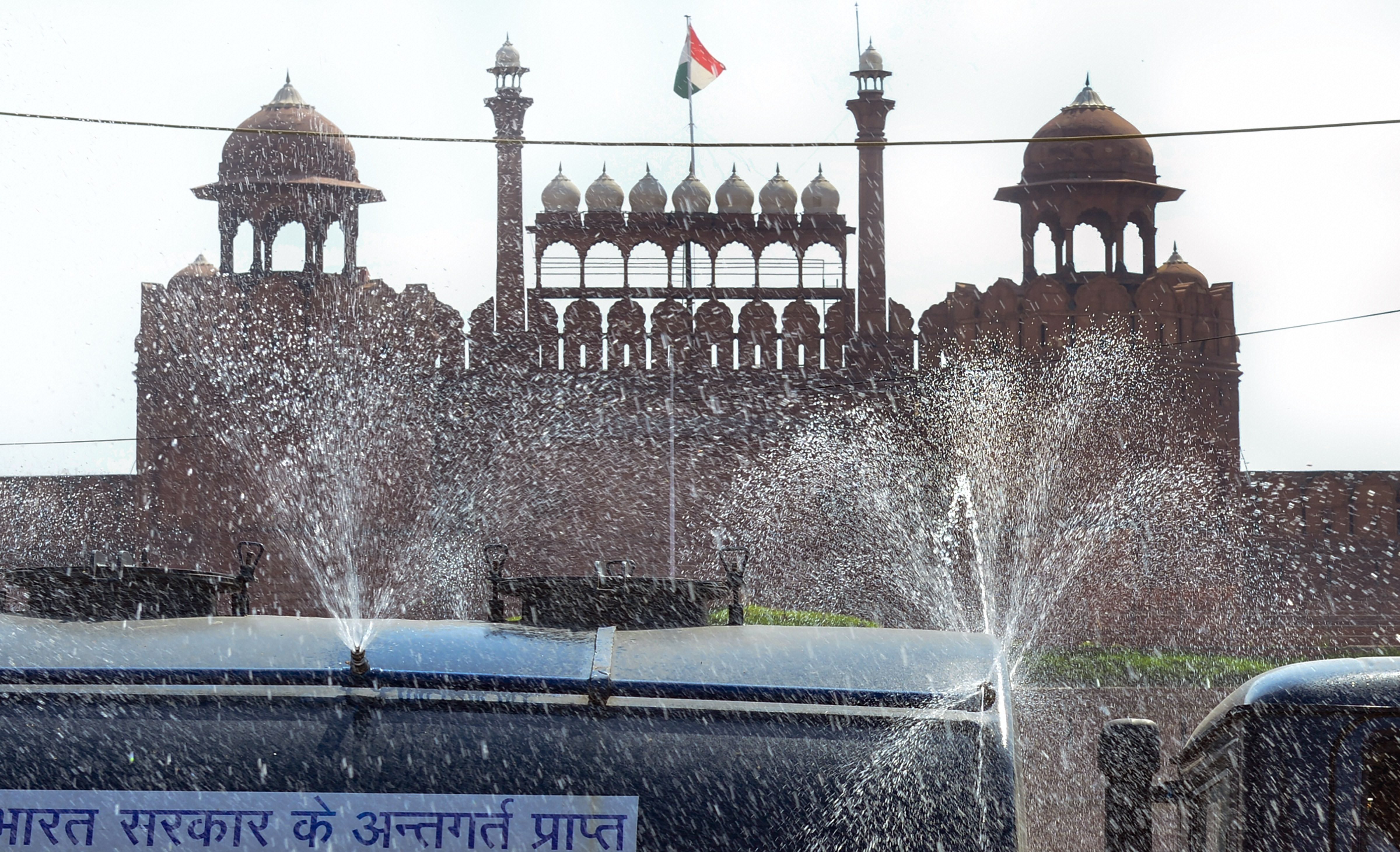 A municipal corporation tanker sprinkles water near the Red Fort as part of sanitisation works during the nationwide lockdown in the wake of coronavirus pandemic, in New Delhi Sunday, April 5, 2020