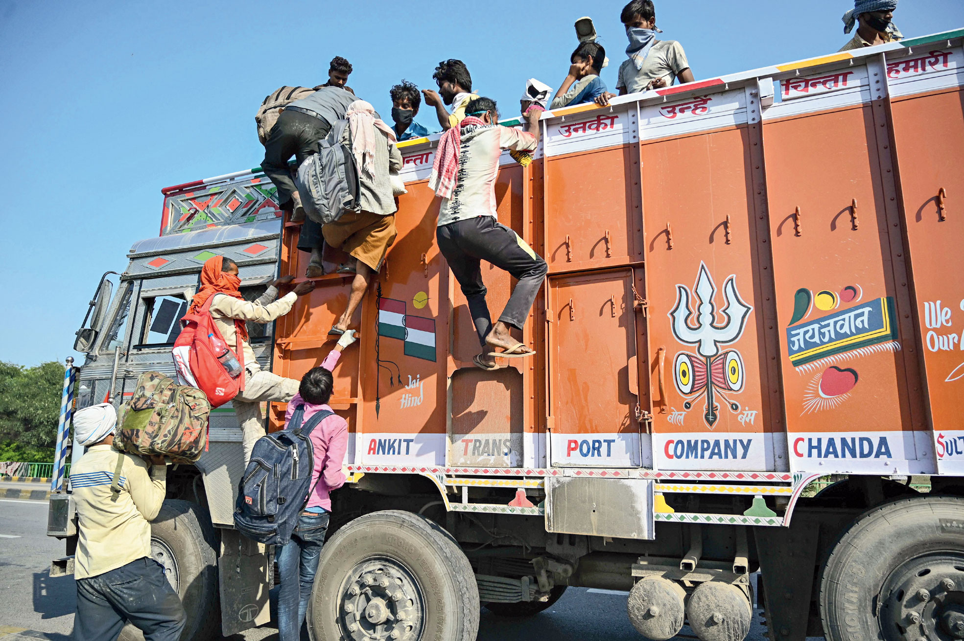 Migrants from Mumbai board a truck at Chakghat border to return to their homes in Madhya Pradesh on Monday.