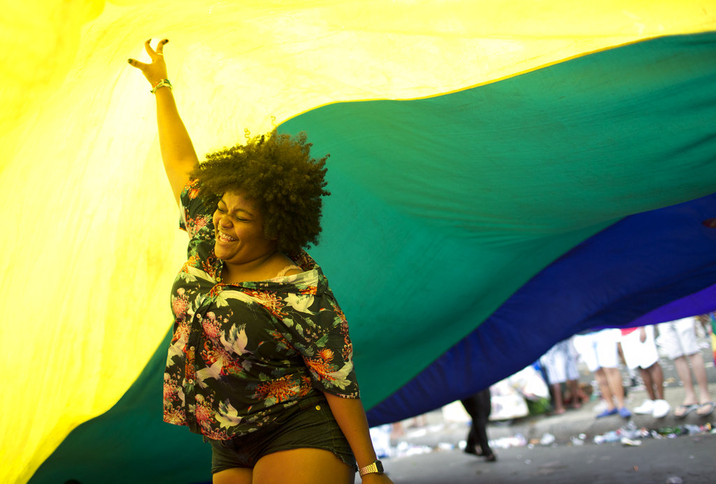 A woman dances under a giant rainbow flag at Brazil's Gay Pride Parade along the Copacabana beach in Rio de Janeiro on Sunday.