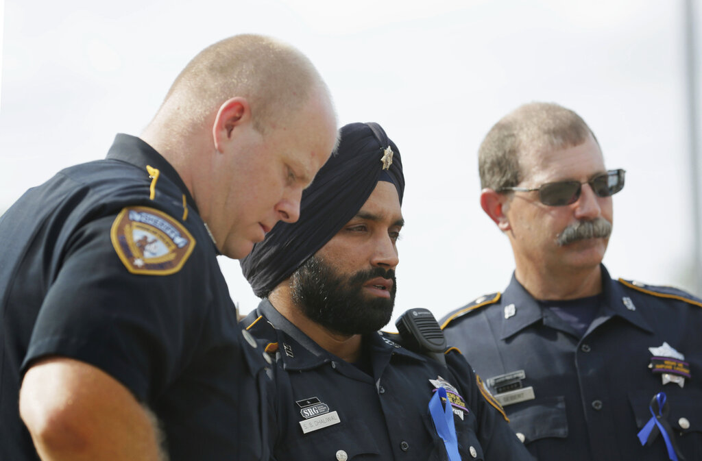 In this August 30, 2015, photo, Harris County Sheriff's Deputy Sandeep Dhaliwal, centre, grieves with his colleagues at a memorial for a slain deputy in Houston. Dhaliwal was shot and killed while making a traffic stop Friday, September 27, 2019, near Houston