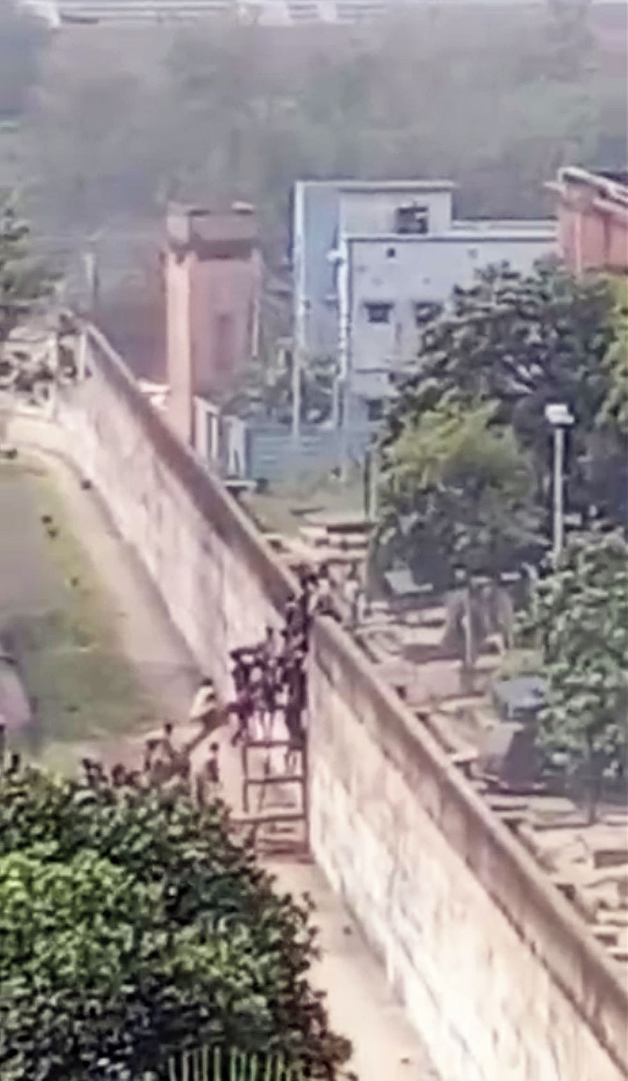 A still from a video of inmates scaling a boundary wall of the jail