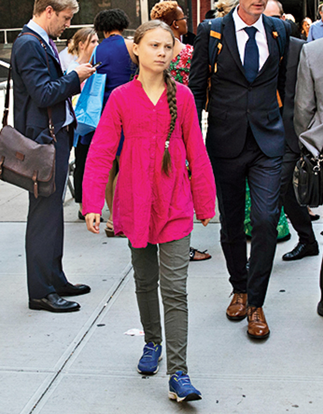 Greta Thunberg walks with an entourage after passing a security checkpoint while appearing at the United Nations, Monday, September 23, 2019 in New York.