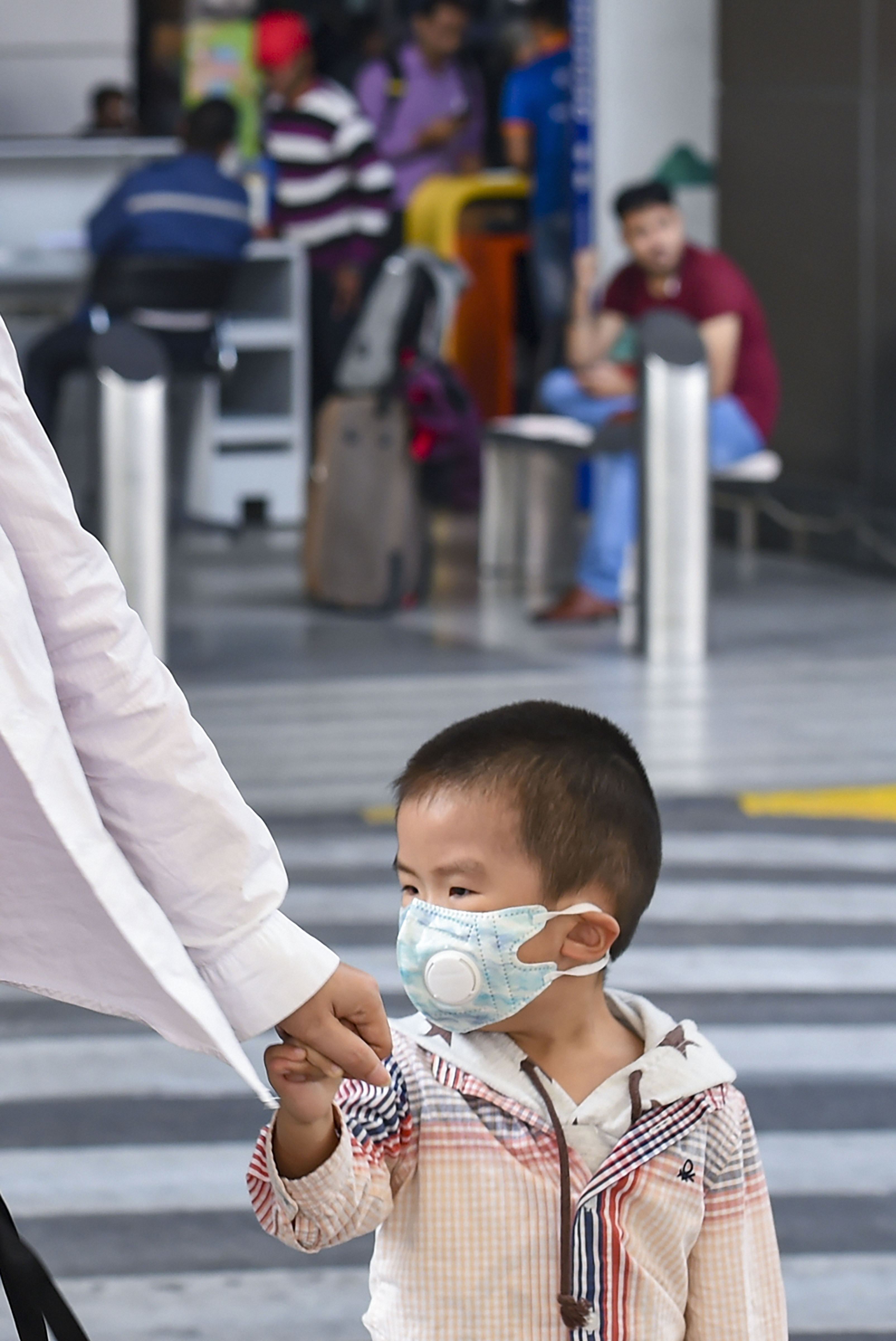  A child, wearing a mask for protection from air pollution, walks at T-3 of the IGI airport, in New Delhi, Wednesday, November 20, 2019.