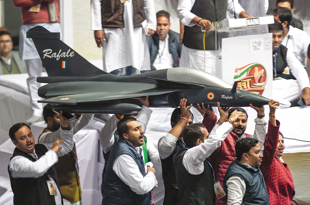 Youth Congress workers holding a model of the Rafale aircraft during the Yuva Kranti Yatra at Talkatora Stadium in New Delhi on January 30