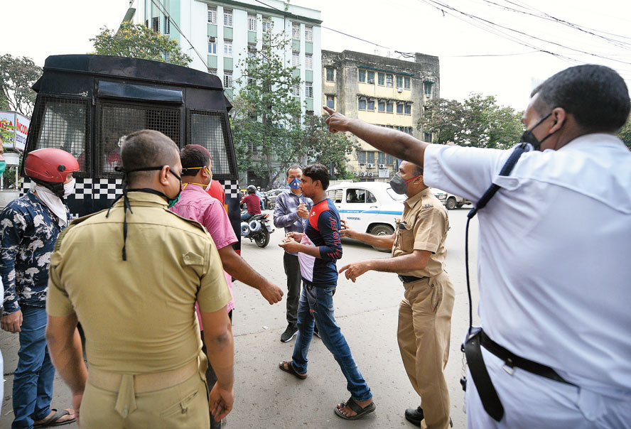 Cops ask a man not wearing a mask to board a police van in Chandni Chowk on Tuesday evening. 