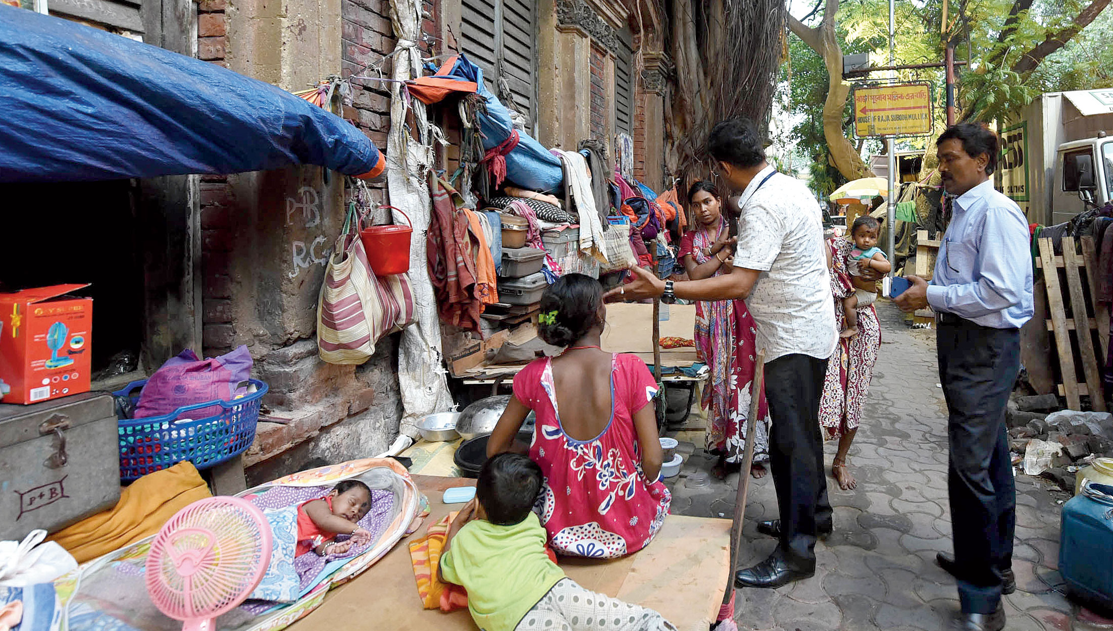 Pavement dwellers being asked to vacate the space in front of a dilapidated building in Bowbazar