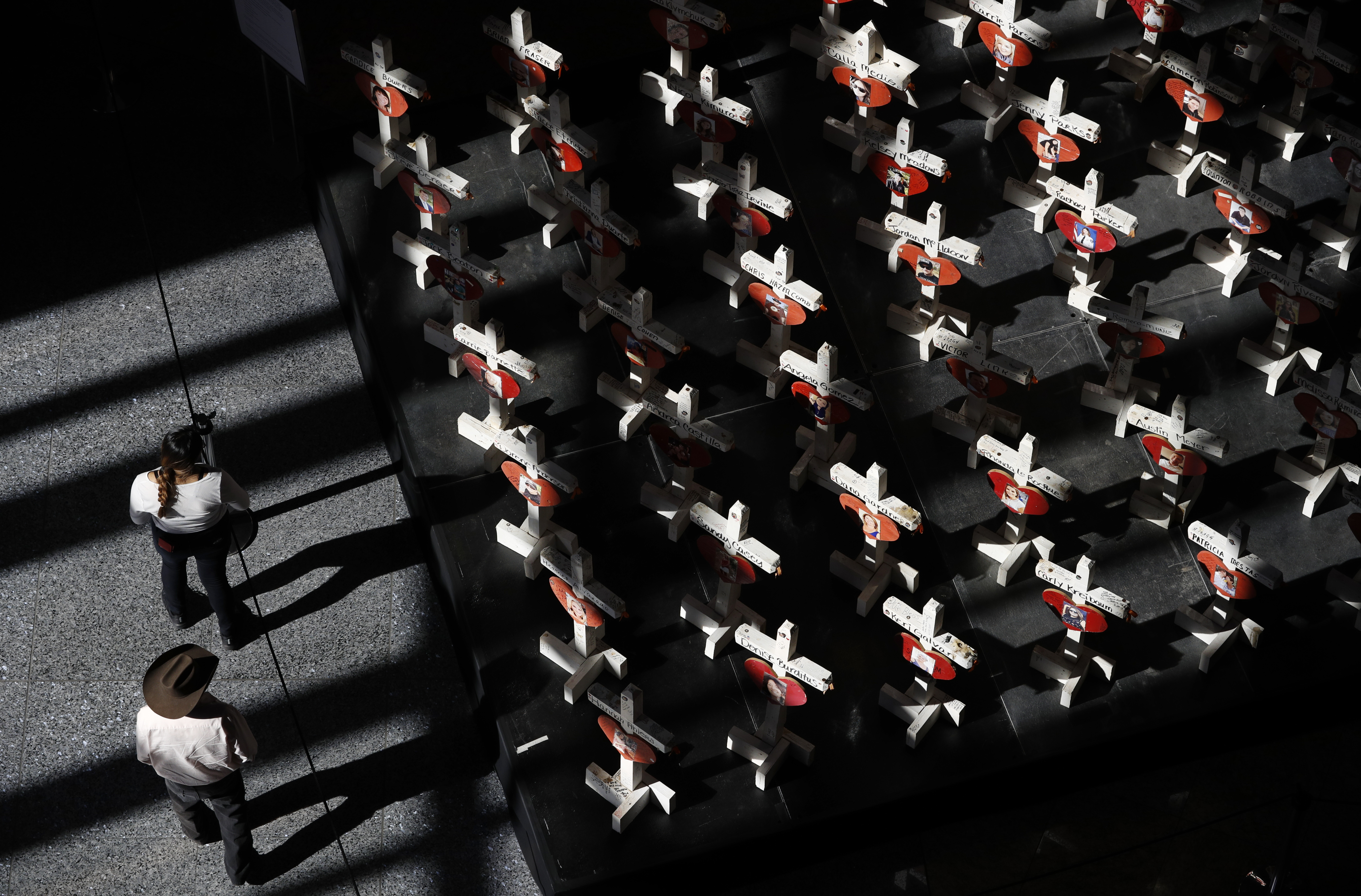 People look at a display of wooden crosses and a Star of David on display at the Clark County Government Center in Las Vegas. The crosses and Star of David had been part of a makeshift memorial along the Las Vegas Strip erected in memory of the victims of the Oct. 1, 2017, mass shooting.