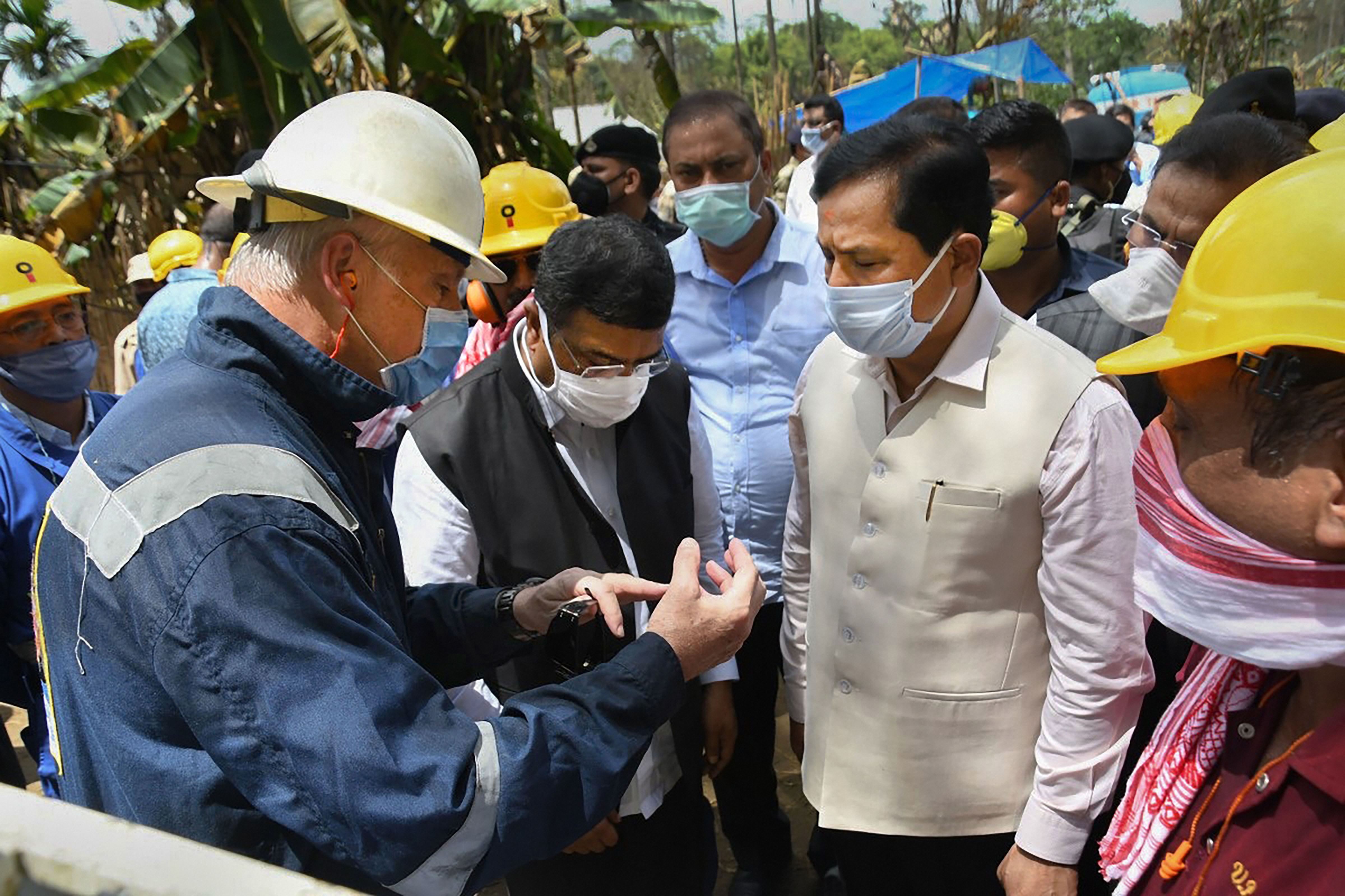 Sarbananda Sonowal and Dharmendra Pradhan take stock of measures taken by experts to douse fire at Baghjan gas well site in Tinsukia District on Sunday. 