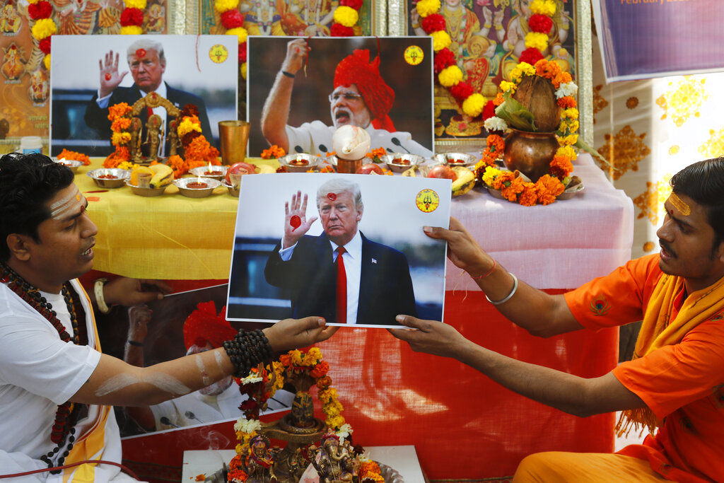 Hindu priests offer prayers holding a portrait of U.S. President Donald Trump in New Delhi, India, Monday