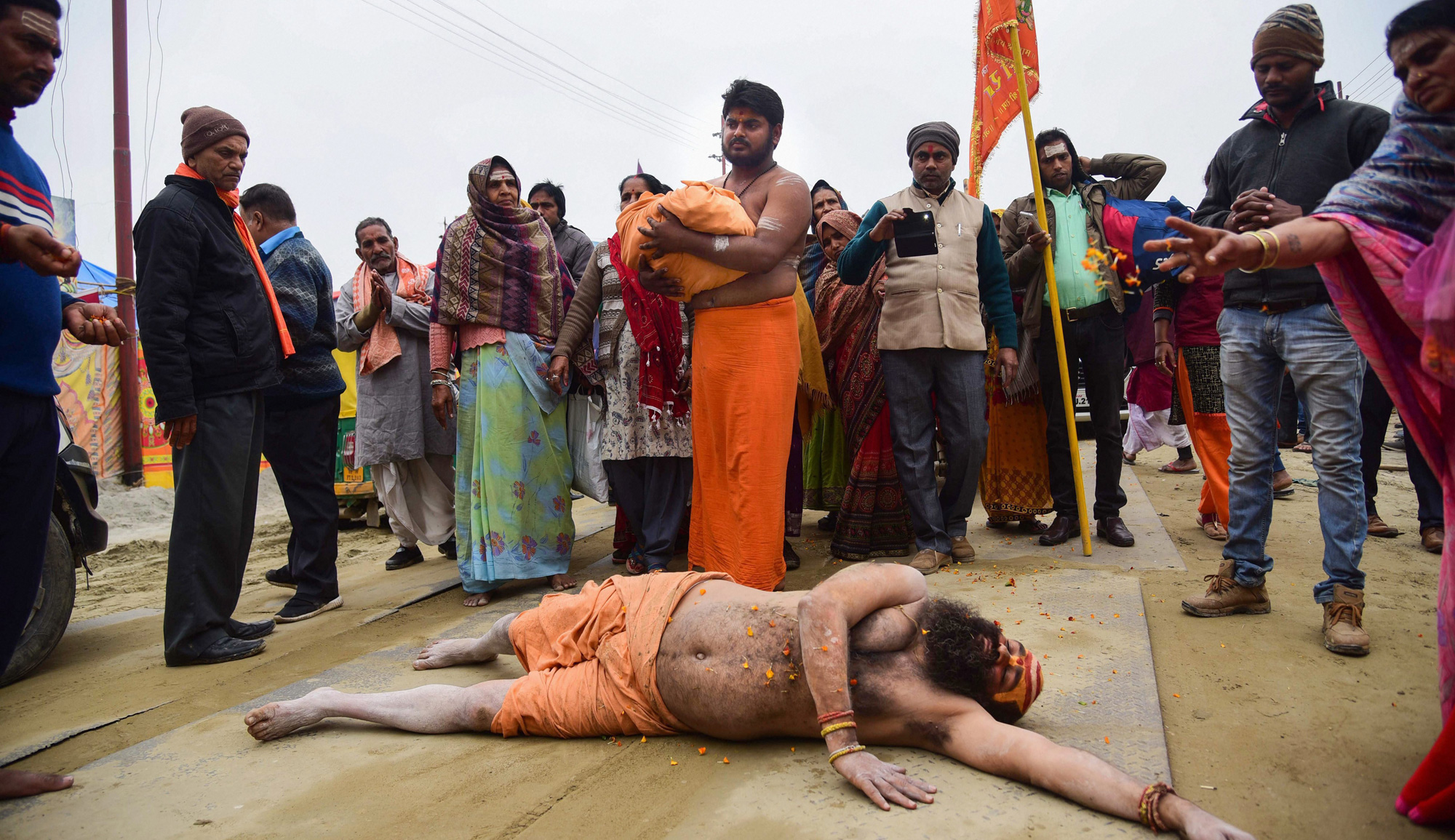 A sadhu rolls on the road as an appeal to build Ram Mandir at Ayodhya, during Kumbh Mela in Allahabad on Sunday, January 27, 2019. 