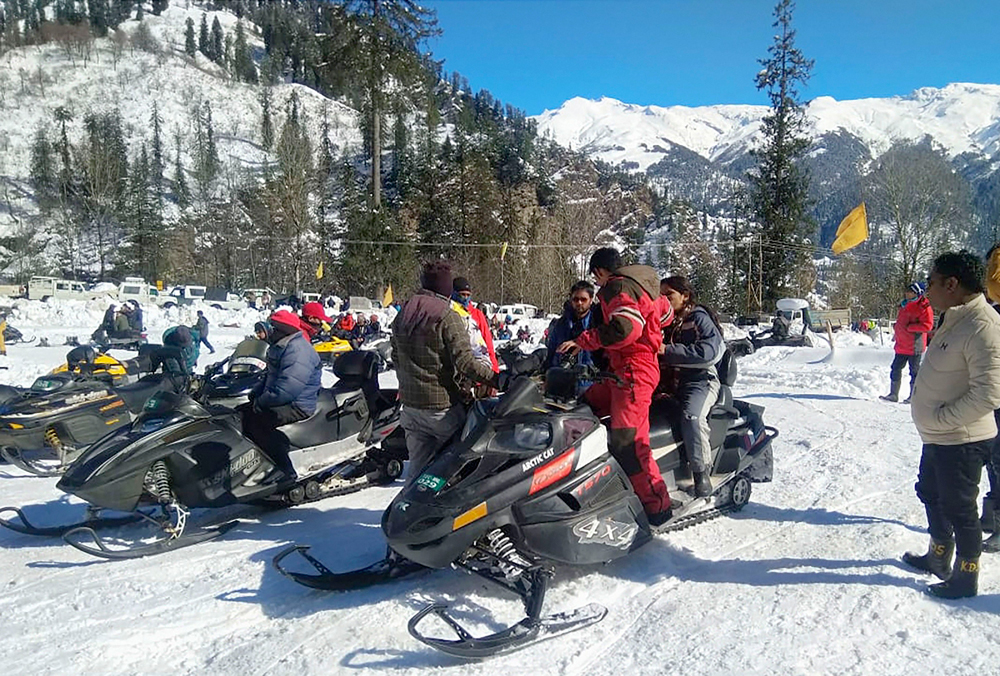 Tourists prepare for rides on snow scooters following fresh snowfall in Manali on December 16