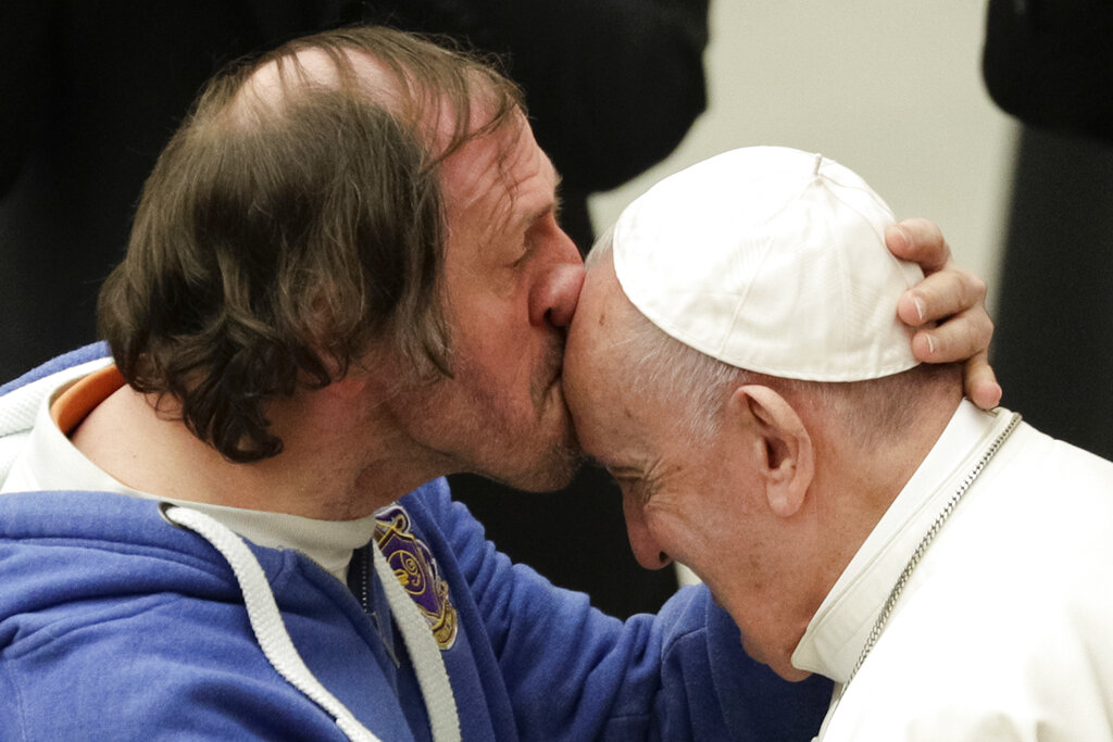 Pope Francis is kissed by a man during his weekly general audience, at the Pope Paul VI hall, at the Vatican, Wednesday
