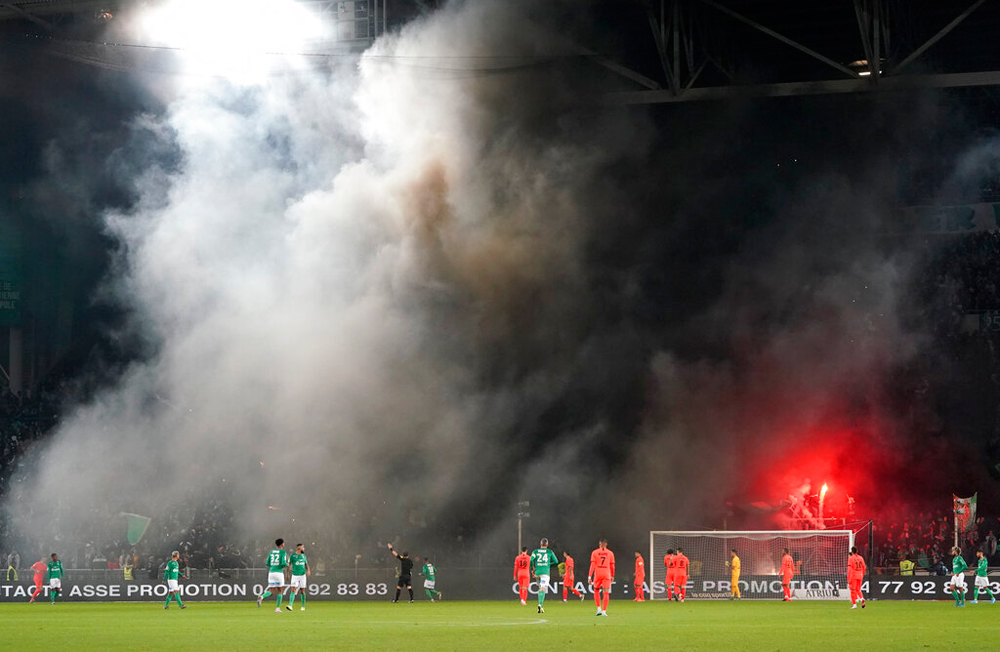 Saint-Etienne's fans light flares during the French League One soccer match between the club and Paris Saint-Germain in Saint-Etienne, France, on December 15
