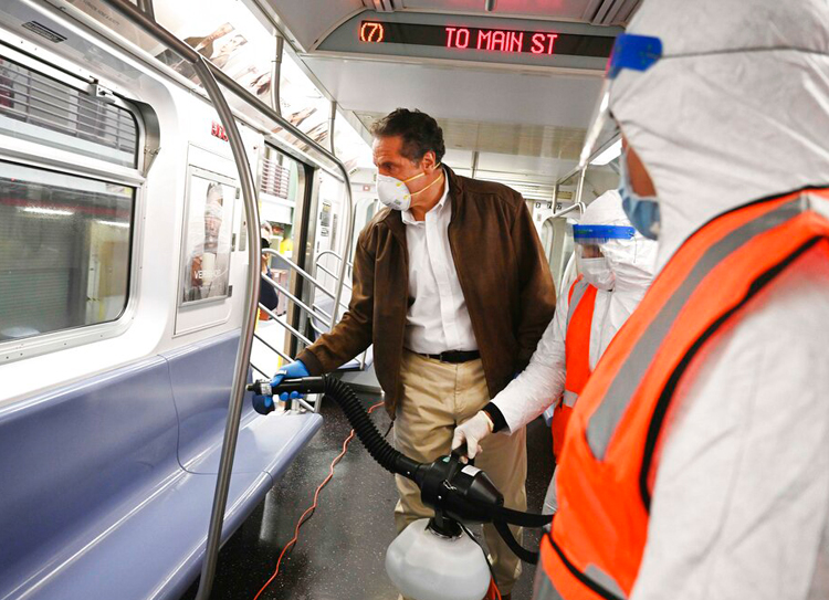 In this photo provided by the Office of Governor Andrew M. Cuomo, New York Gov. Cuomo tries out a spraying device which is part of a three-step disinfecting process of a New York City subway car at the Corona Maintenance Facility in the Queens borough of of New York, Saturday, May 2, 2020.