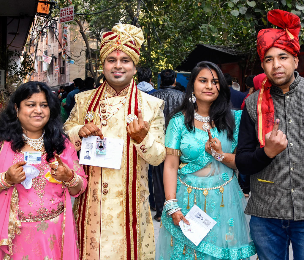 A groom and his family members after casting their votes for Delhi Assembly elections, at a polling station in east Delhi, on Saturday