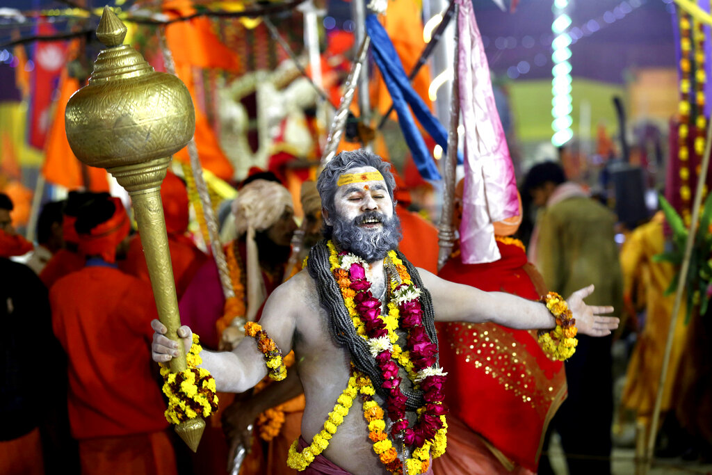 A man holding a mace dances his way into the festival. Four sites in India rotate every three years hosting the Kumbh, the world's largest pilgrimage. The river baths, prayer, meditation and yoga sessions and other religious rituals are organised by sadhus, and financially supported with public funds.