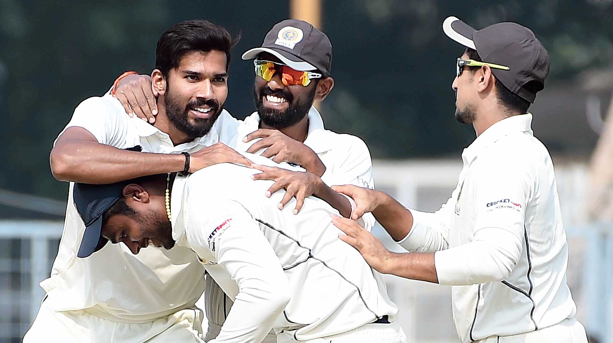 Sandeep Warrier celebrates with teammates after the fall of a Bengal wicket, at the Eden on Thursday. 