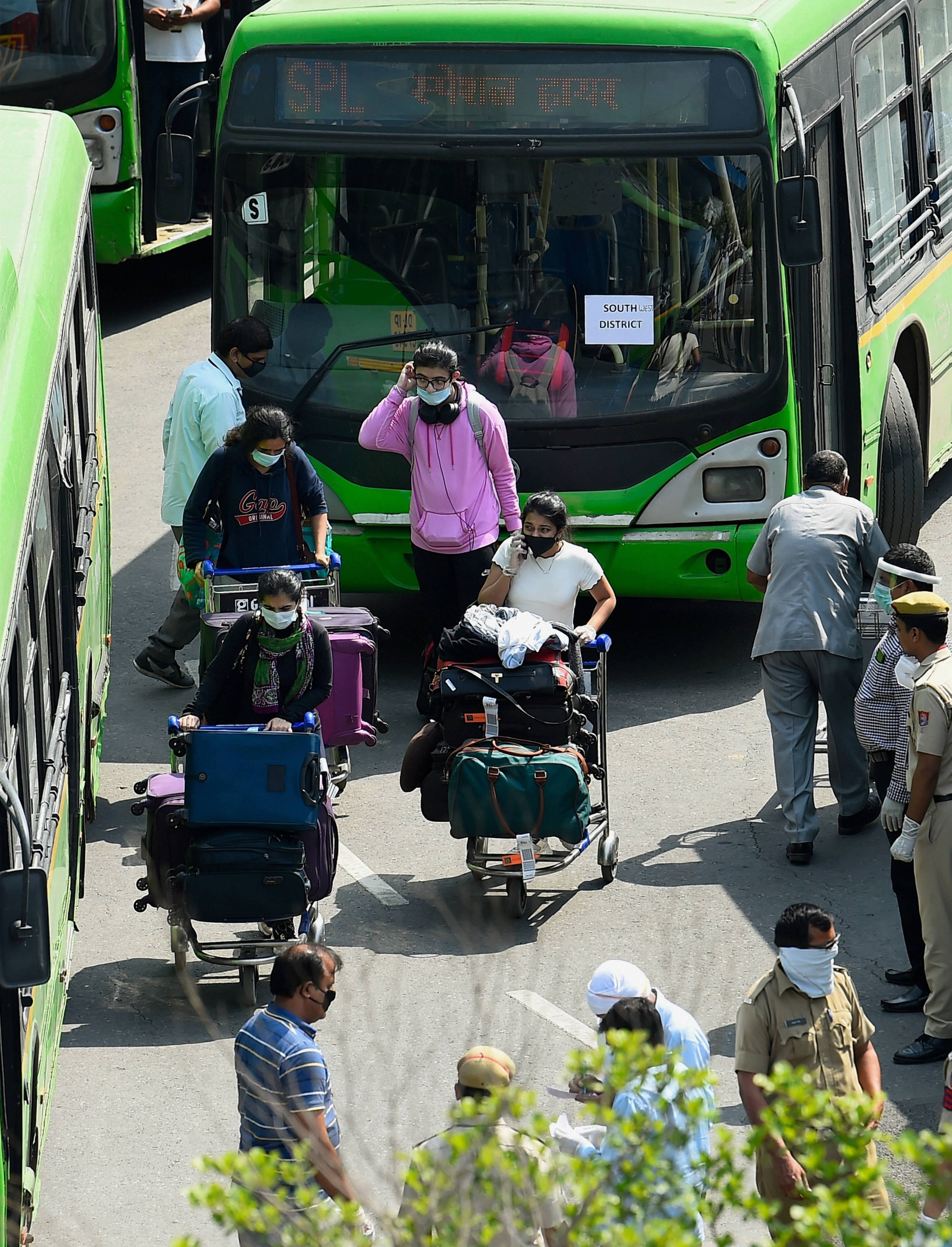Indian nationals, who were stranded in Singapore amid Covid-19 pandemic, prepare to leave in buses after they were brought by a special Air India flight at IGI Airport in New Delhi, Friday, May 8, 2020.