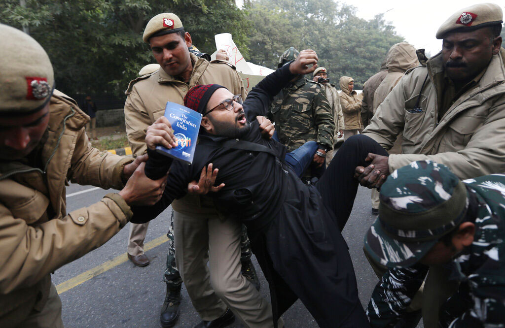 Police officers detain a protesting student outside Uttar Pradesh Bhawan during a protest against the amended citizenship act in New Delhi on Friday.
