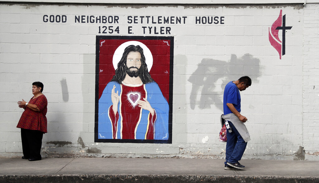 Marianela Ramirez Watson (left) stands outside the Good Neighbor Settlement House in Brownsville, Texas, as a person walks by the shelter for migrants released from the US immigration detention.