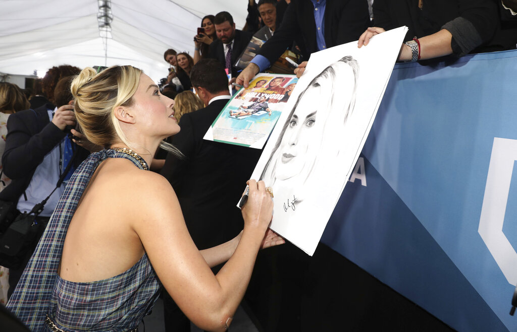 Margot Robbie signs an autograph as she arrives at the 26th annual Screen Actors Guild Awards at the Shrine Auditorium & Expo Hall on Sunday, January 19, 2020, in Los Angeles