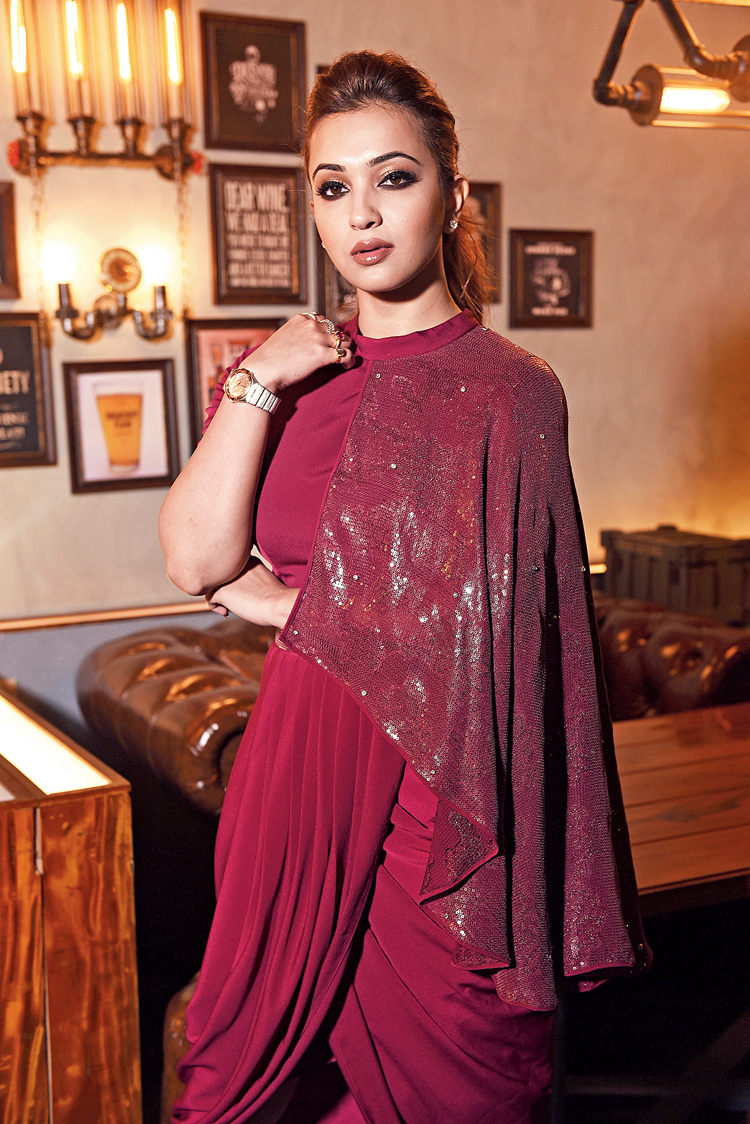 This dark wine outfit made of wrinkled crepe with stylish drapes and pleats on the lower part and an elaborate sequinned sleeve on one side adding a touch of bling, could well be your New Year’s Eve OTTN! “This outfit from our Drape Series is a perfect evening-wear with its chic and modern design appeal. The draping and pleating is conceptualised in a contemporary manner,” said Jyotee. “The Indo-western style of this outfit is very attractive,” said Koushani.