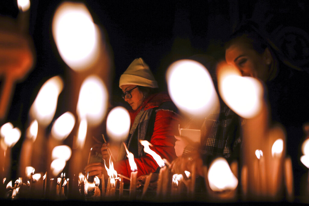 Catholic Christians light candles as they participate at a Christmas Eve Mass in St. Antoine Church, the largest church of the Roman Catholic Church, in Istanbul, Tuesday, Dec. 24, 2019.