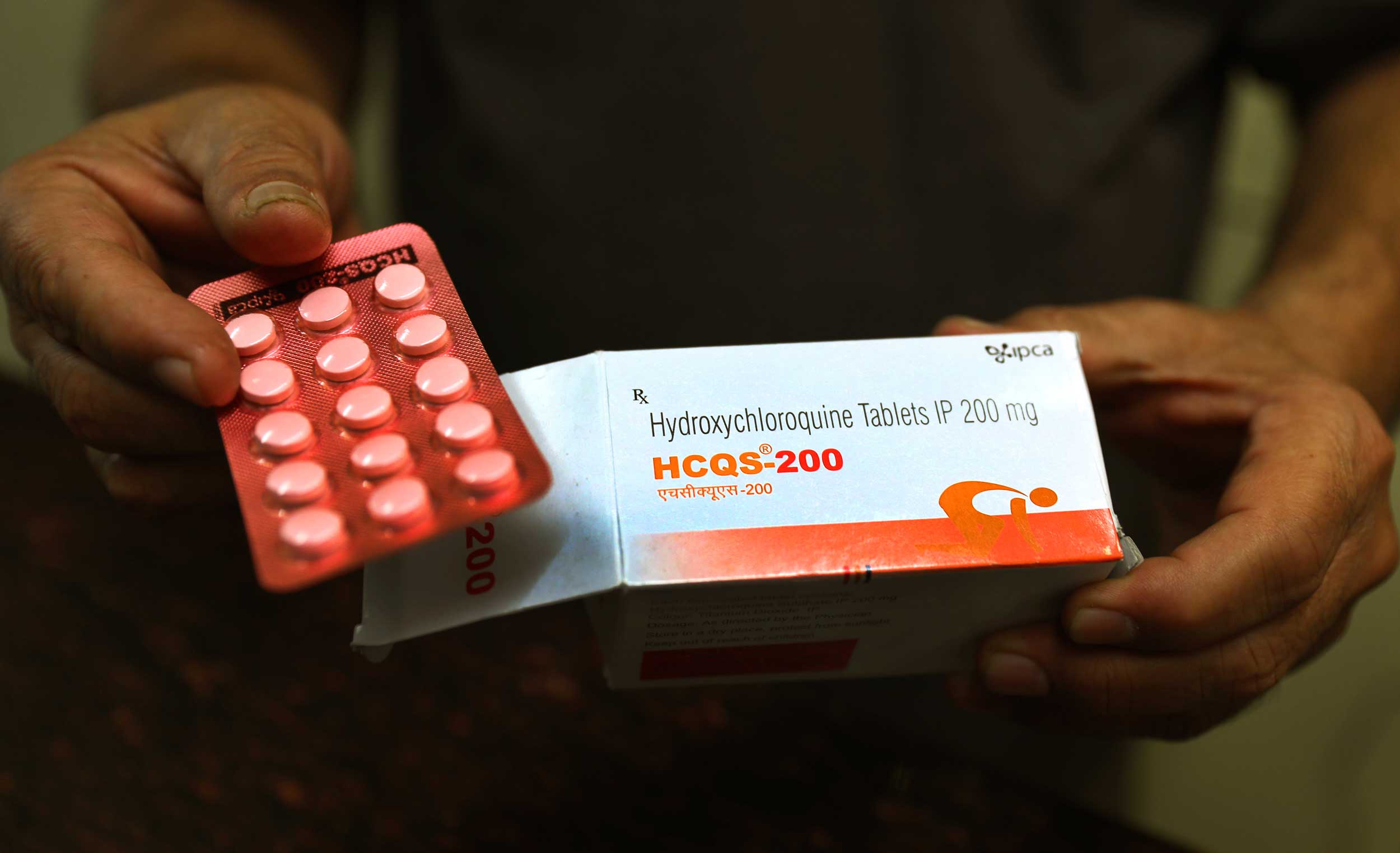 A chemist with hydroxychloroquine tablets