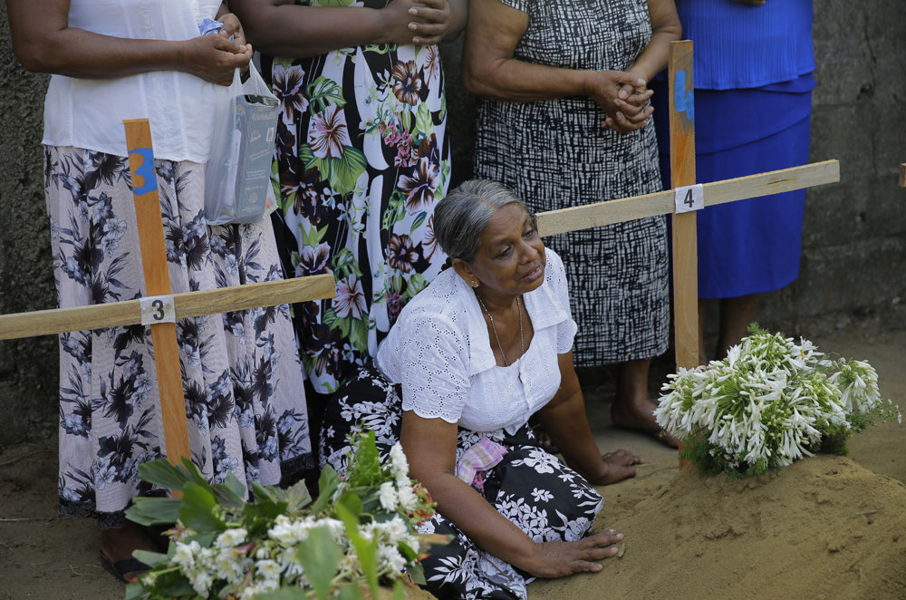 A woman weeps next to the grave of a family member who died in the Easter Sunday bomb blast, in Katuwapitiya village in Negombo, Sri Lanka on Wednesday, April 24, 2019. 