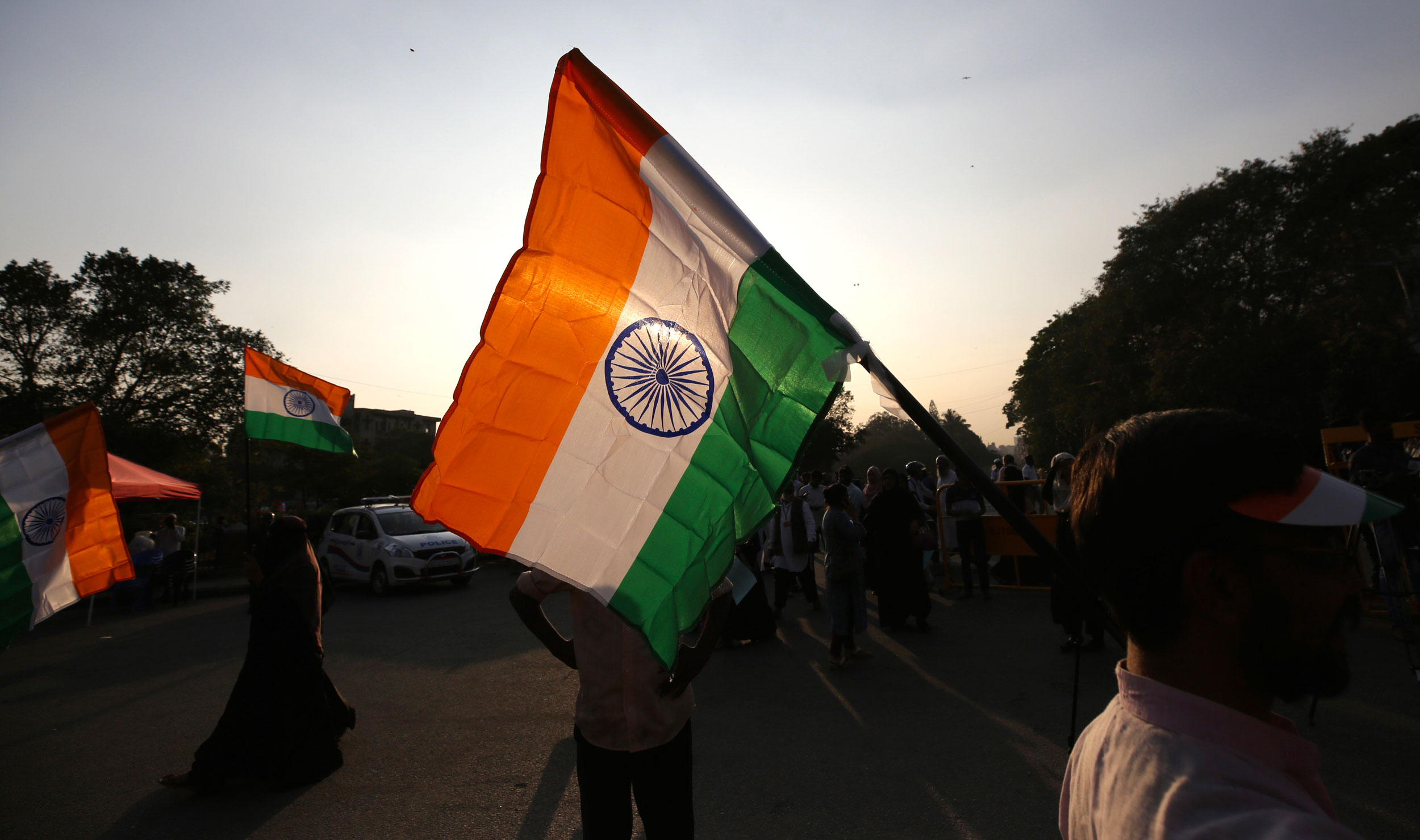 People carry national flags as they walk to join others to form a human chain to mark the death anniversary of Mahatma Gandhi and to protest the new citizenship act in Bangalore on Thursday.