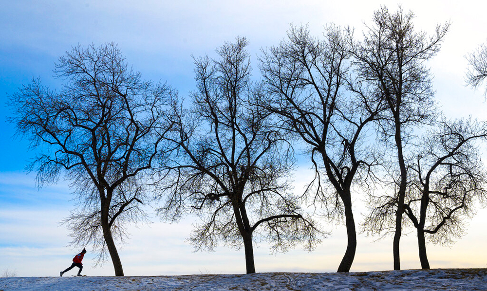 A skateboarder cruises around Prospect Lake in Memorial Park in Colorado Springs
