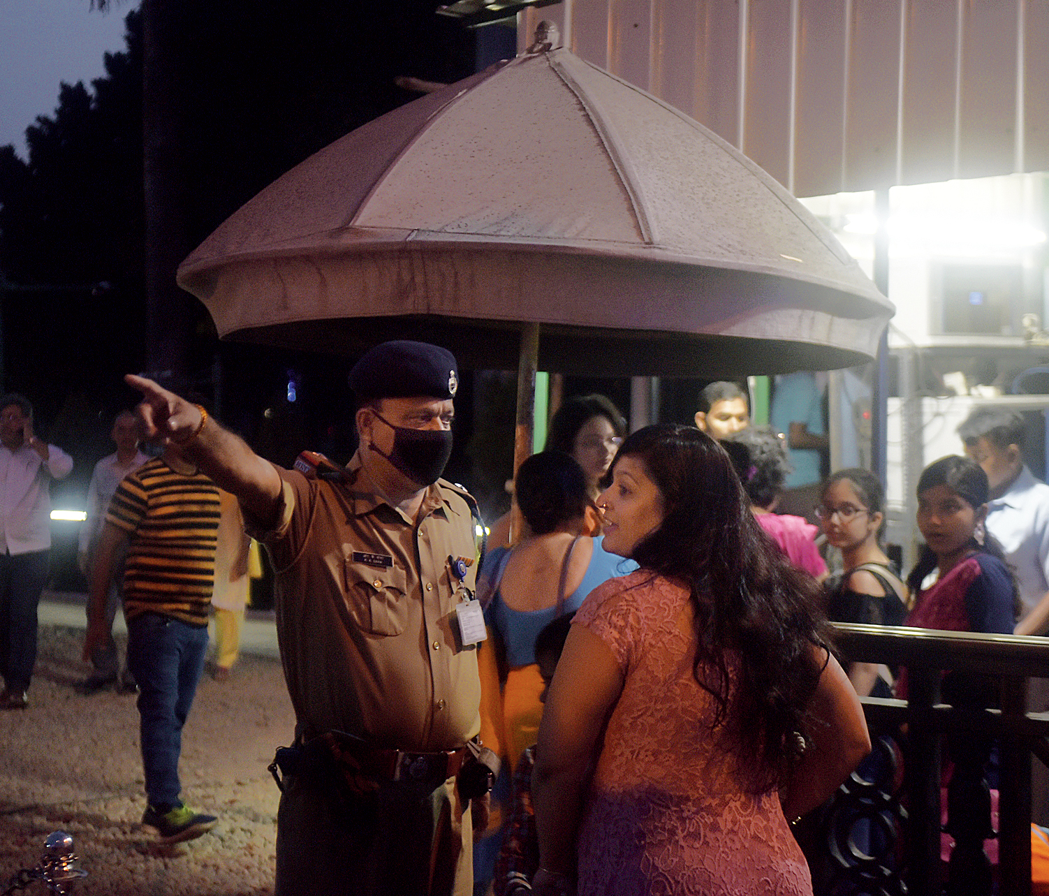 A policeman in a mask speaks to a visitor at Victoria Memorial on Saturday evening. 
