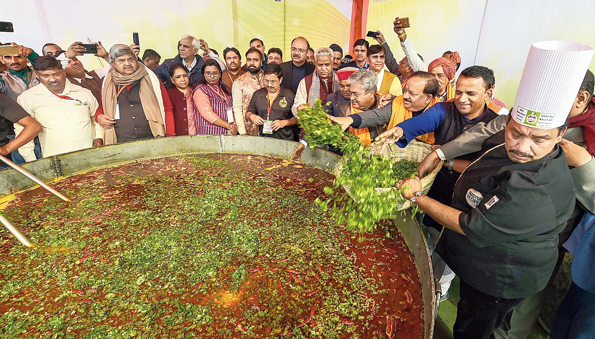 Union ministers Harsh Vardhan and Thaawar Chand Gehlot and other BJP leaders prepare khichdi during an event called Bhim Mahasamagam on Ramlila Maidan in New Delhi on Sunday. 
