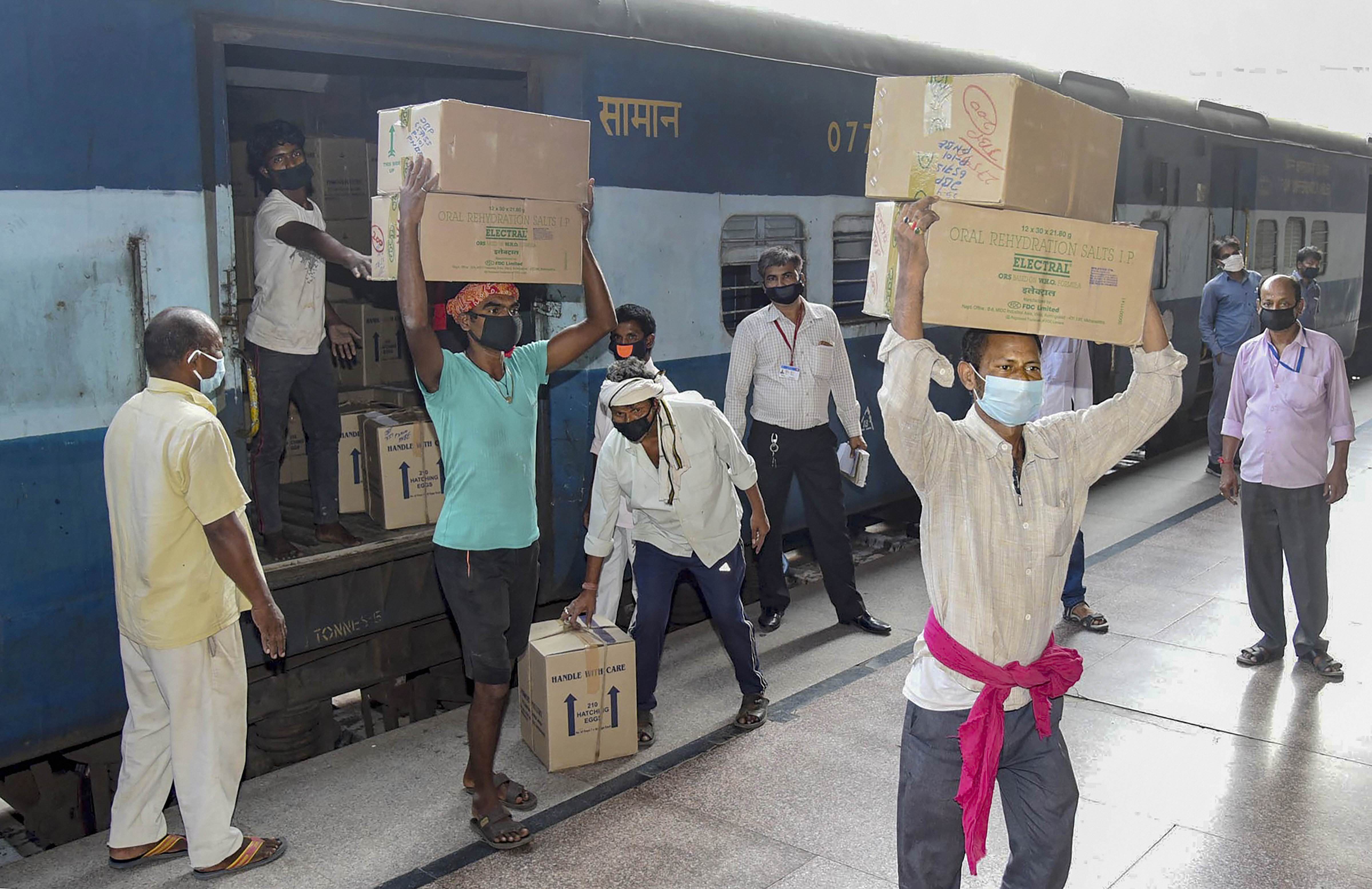Workers unloading consignment of medicines from a railway goods wagon during the nationwide lockdown, at Patna Junction, Thursday, April 30, 2020.