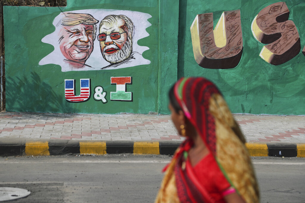 An Indian woman looks at a wall painted with portraits of U.S. President Donald Trump and Indian Prime Minister Narendra Modi ahead of Trump's visit, in Ahmadabad, on Tuesday