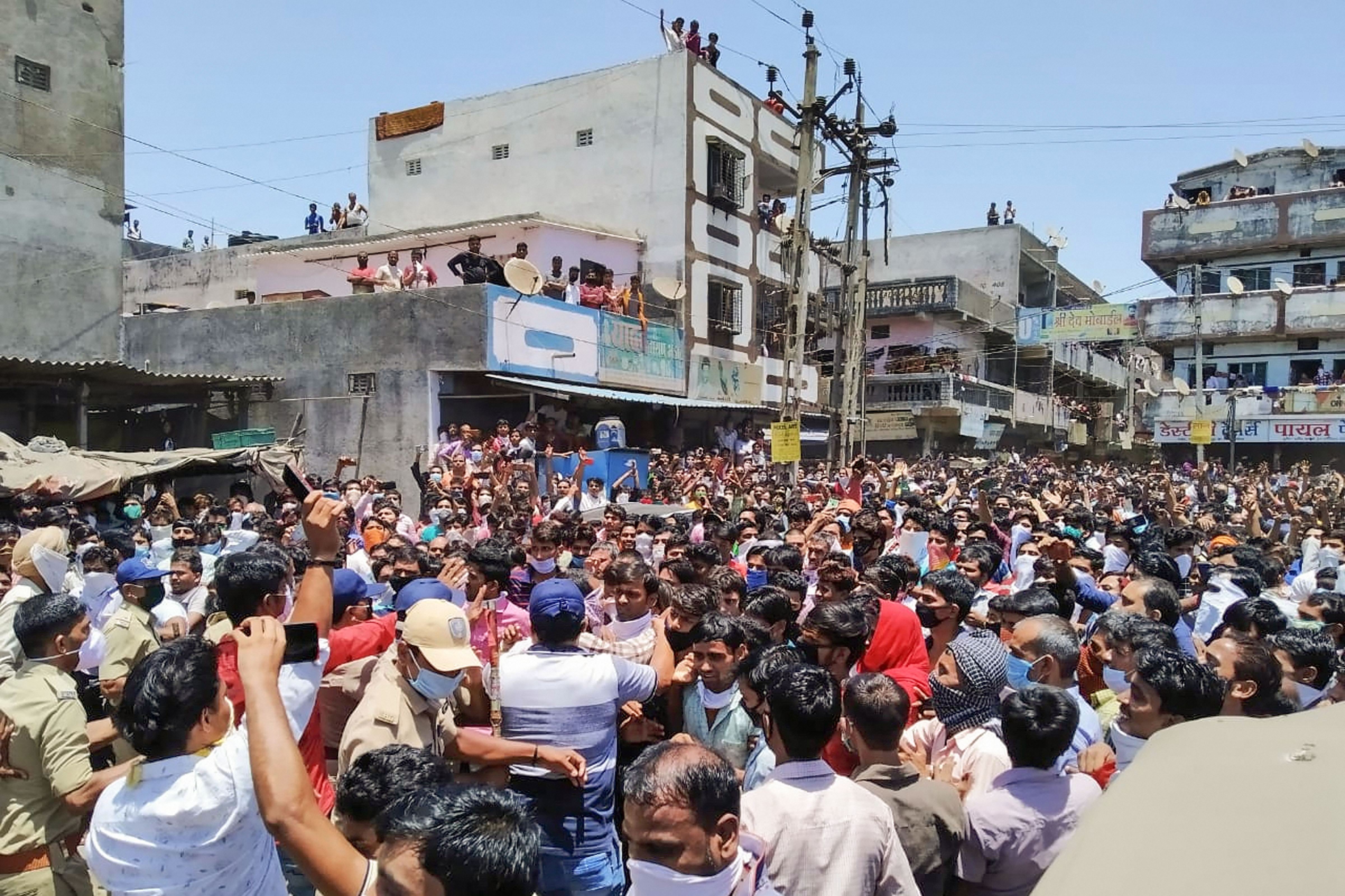 Migrant workers clash with the police during their agitation for arrangements to return to their homes, amid ongoing Covid-19 lockdown in Surat, Monday, May 4, 2020.