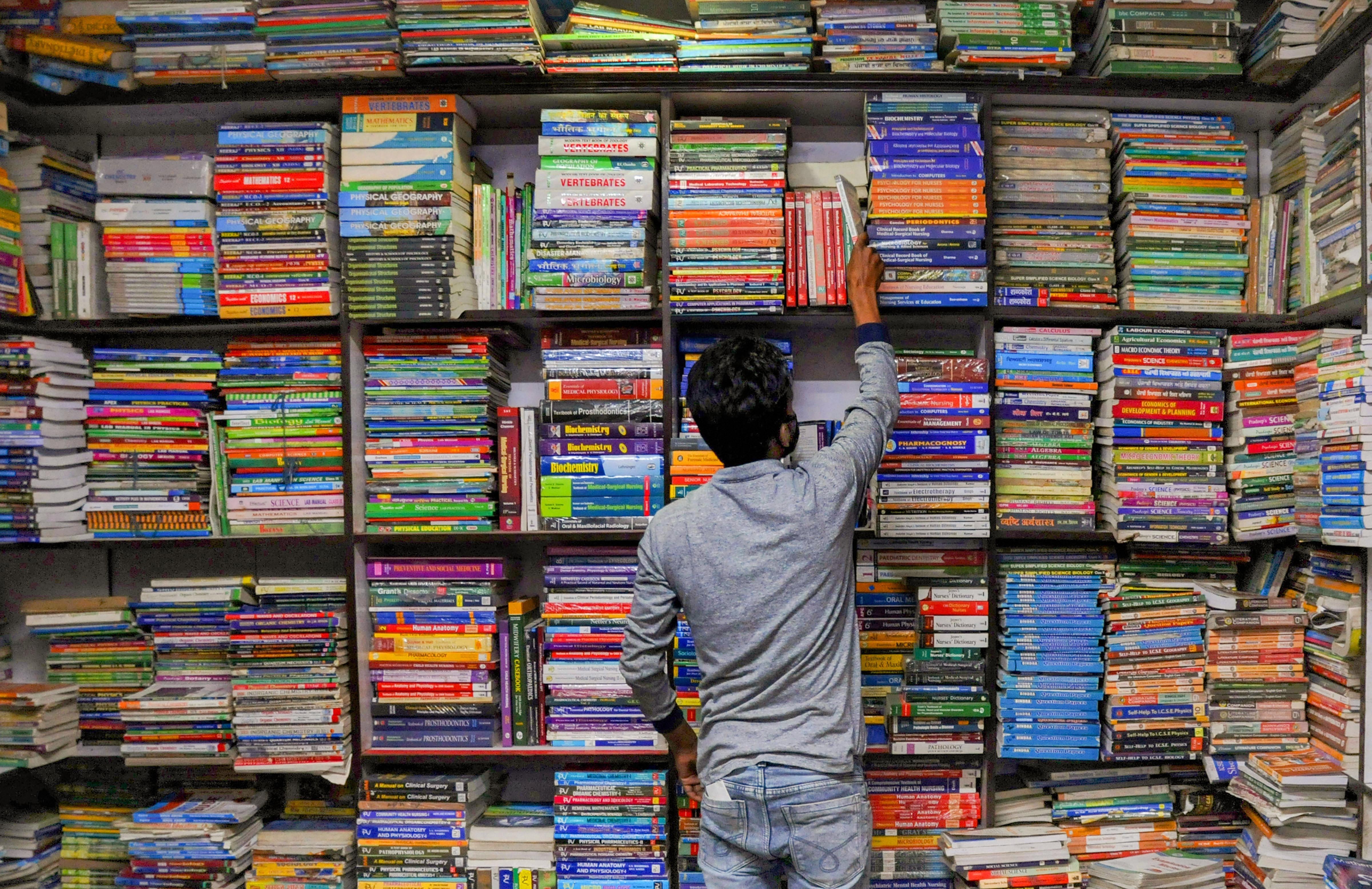 A vendor sorts books inside a shop, during the nationwide lockdown to curb the spread of coronavirus, in Amritsar, Thursday, April 23, 2020.