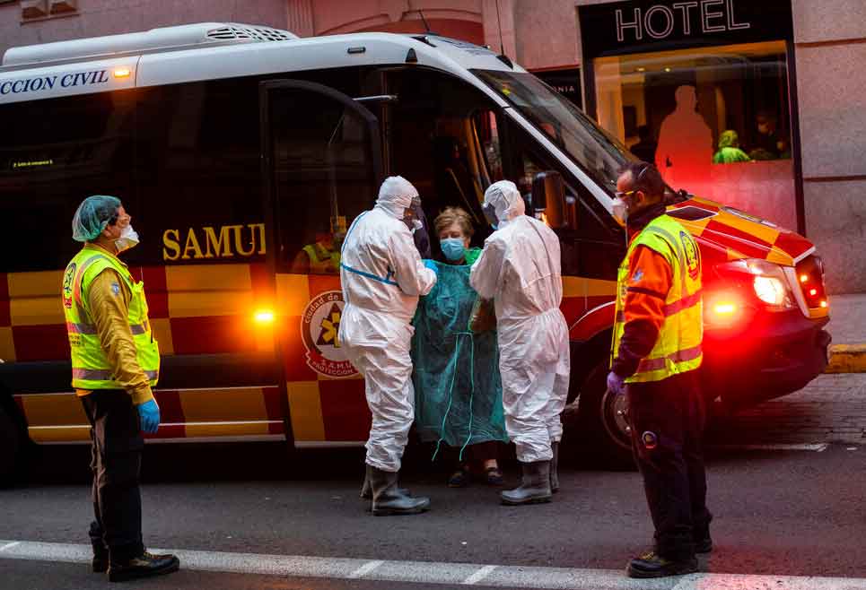 A patient, center, is transferred to a medicalised hotel during the COVID-19 outbreak in Madrid, Spain, Tuesday, March 24, 2020.