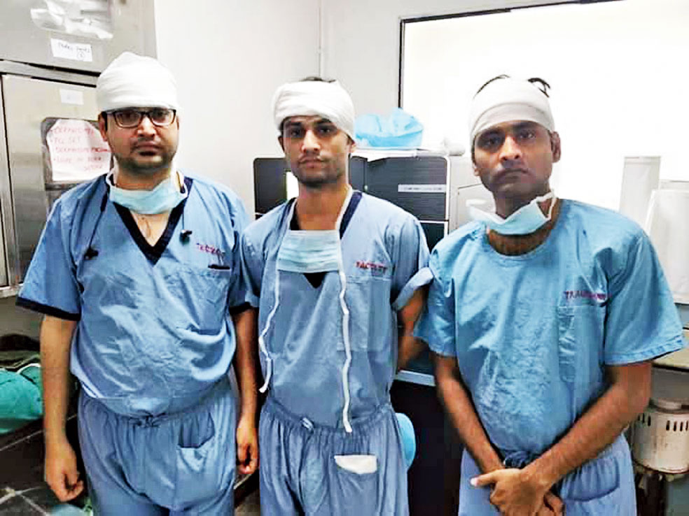AIIMS doctors pose wearing bandages before an operation.