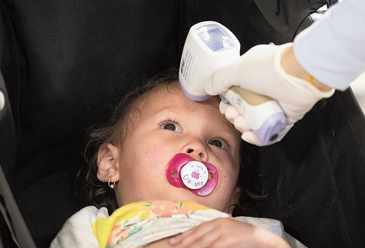 An official checks the temperature of a baby at the Suvarnabhumi Airport in Bangkok on Wednesday