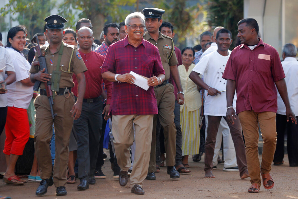 Gotabaya Rajapaksa (centre) leaves a polling station after casting his vote in Embuldeniya, on the outskirts of Colombo, on Saturday