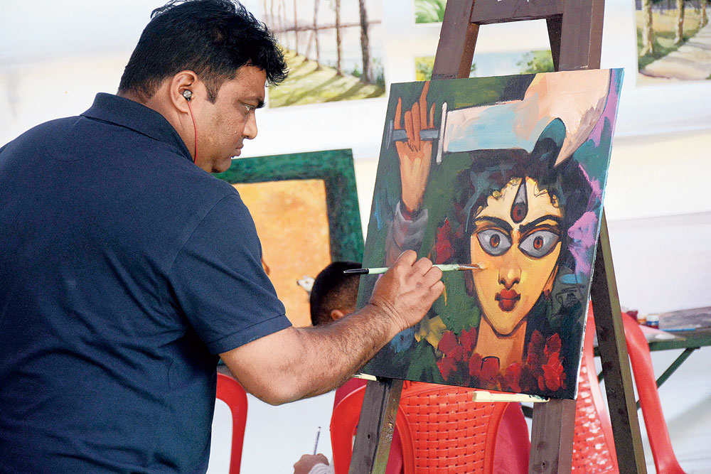 An artist painting at the workshop-cum-exhibition at Rabindra Bhavan in Jamshedpur