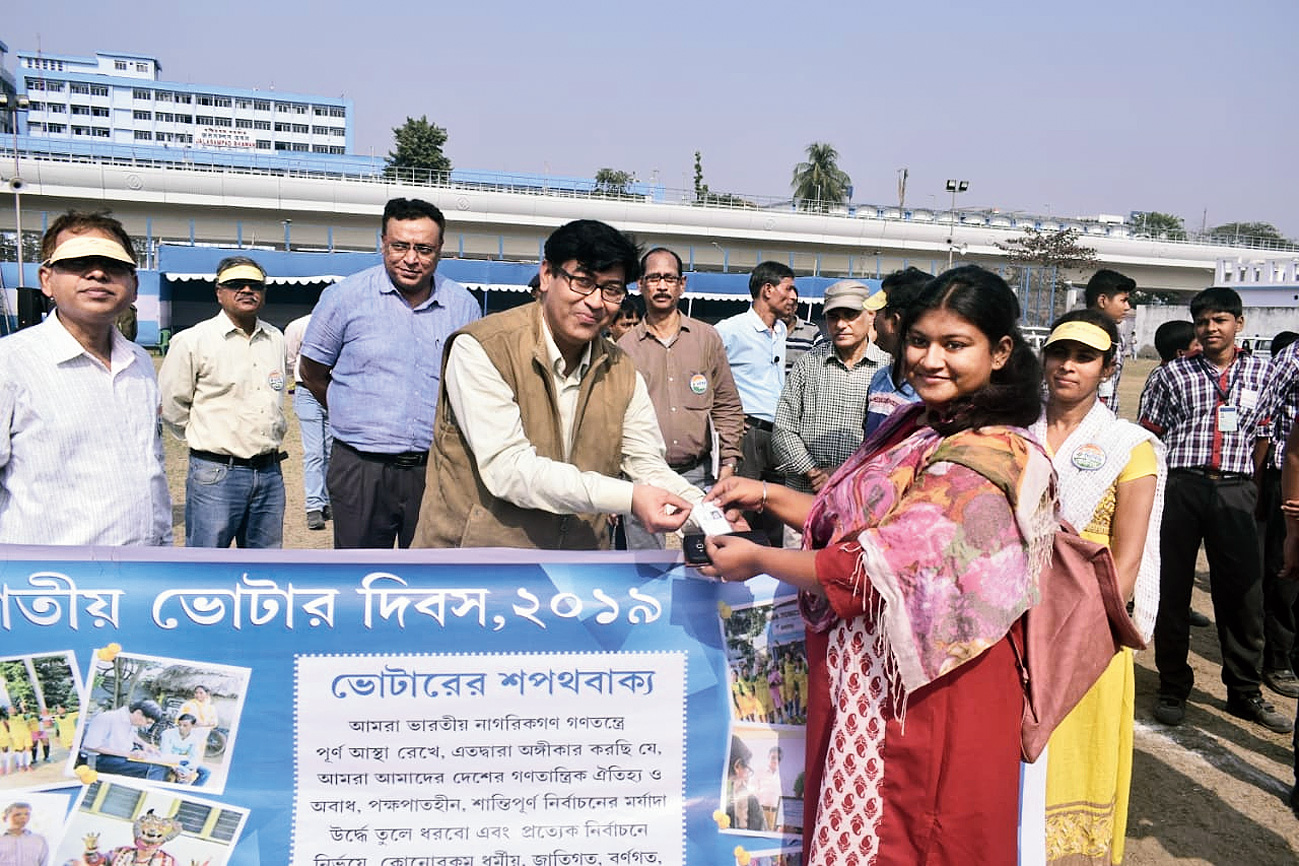 Deputy magistrate Manish Das hands over EPIC to first time voter Rupshali Ghosh.