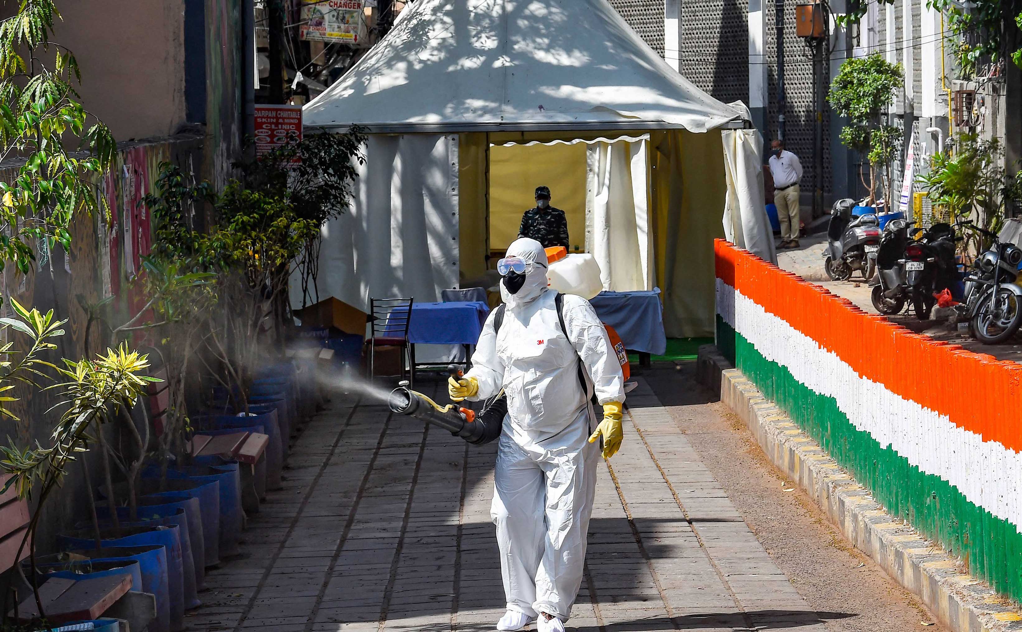 A health worker sanitises an area near Nizamuddin mosque, after people who attended the religious congregation at Tabligh Jamaats, tested postive for COVID-19