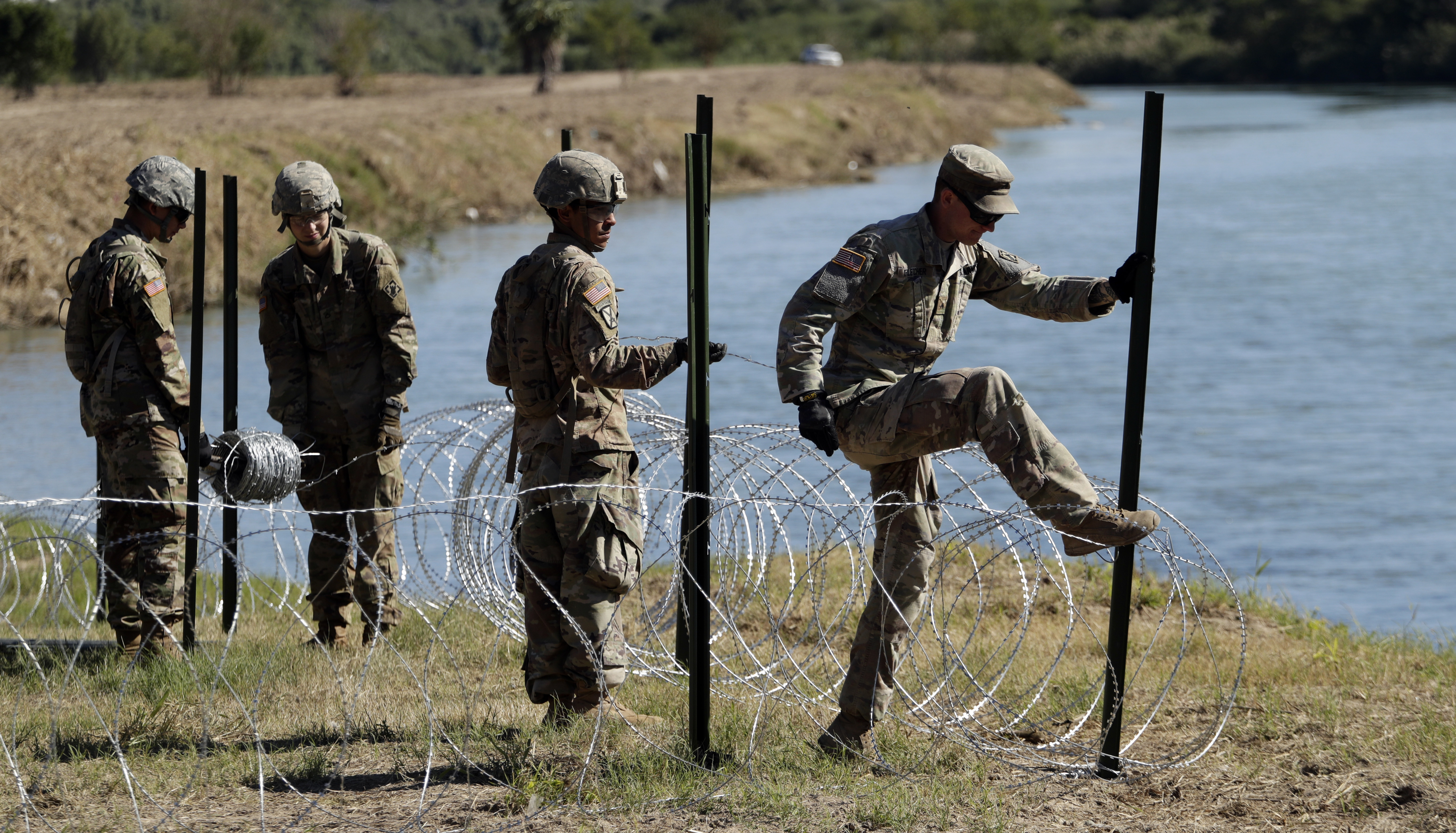 Members of the US military install multiple tiers of concertina wire along the banks of the Rio Grande near the Juarez-Lincoln Bridge at the US-Mexico border on November 16 in Laredo, Texas. 